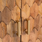 Close up image of a handcrafted mango wood sideboard with hexagonal inlay design and brass-finished legs—artisanal bedroom furniture combining craftsmanship and modern elegance.