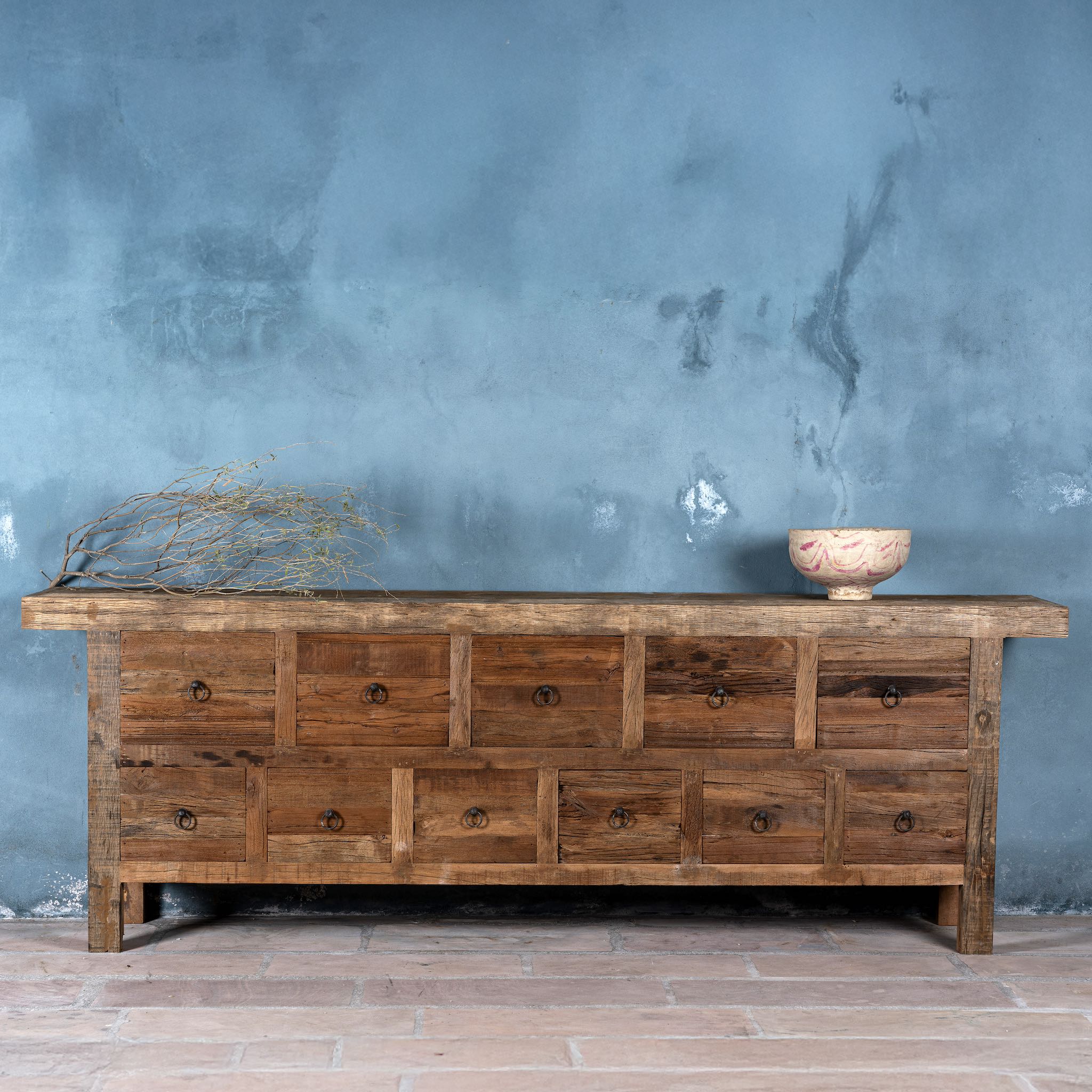 Reclaimed wood console table with rustic finish, multiple drawers, and iron ring pulls; sustainable furniture with driftwood charm, 250 × 40 × 85 cm.