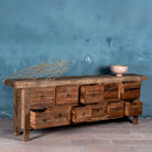 Side view image with open drawers of a reclaimed wood console table with rustic finish, multiple drawers, and iron ring pulls; sustainable furniture with driftwood charm, 250 × 40 × 85 cm.