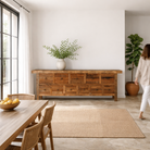 Lifestyle image of a reclaimed wood console table with rustic finish, multiple drawers, and iron ring pulls; sustainable furniture with driftwood charm, 250 × 40 × 85 cm.