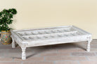 Lifestyle image of a white washed old door coffee table made of antique teak wood; handcrafted Indian coffee table, 185 × 109 × 46 cm.
