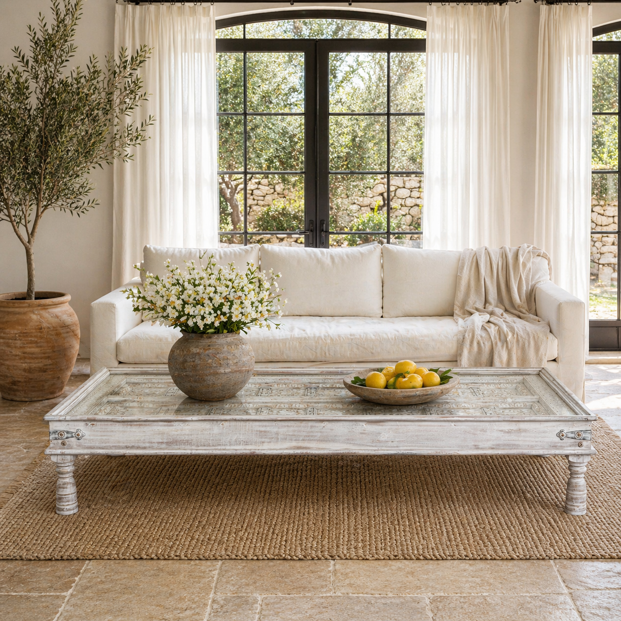 Lifestyle image of a white washed old door coffee table made of antique teak wood; handcrafted Indian coffee table, 185 × 109 × 46 cm.
