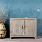 Lifestyle image of a Ibiza style bathroom cupboard made of reclaimed wood with sandblasted finish and two doors, 100 × 50 × 80 cm.