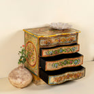 Side angle with open drawers image of a hand-painted reclaimed wood chest of drawers with floral designs and distressed antique finish; perfect for bohemian interiors and vintage hand painted furniture lovers.