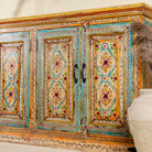 Side angle image of a hand painted wooden dresser with floral and geometric motifs, reclaimed wood living room furniture in vintage boho style, 170 × 45 × 95 cm.