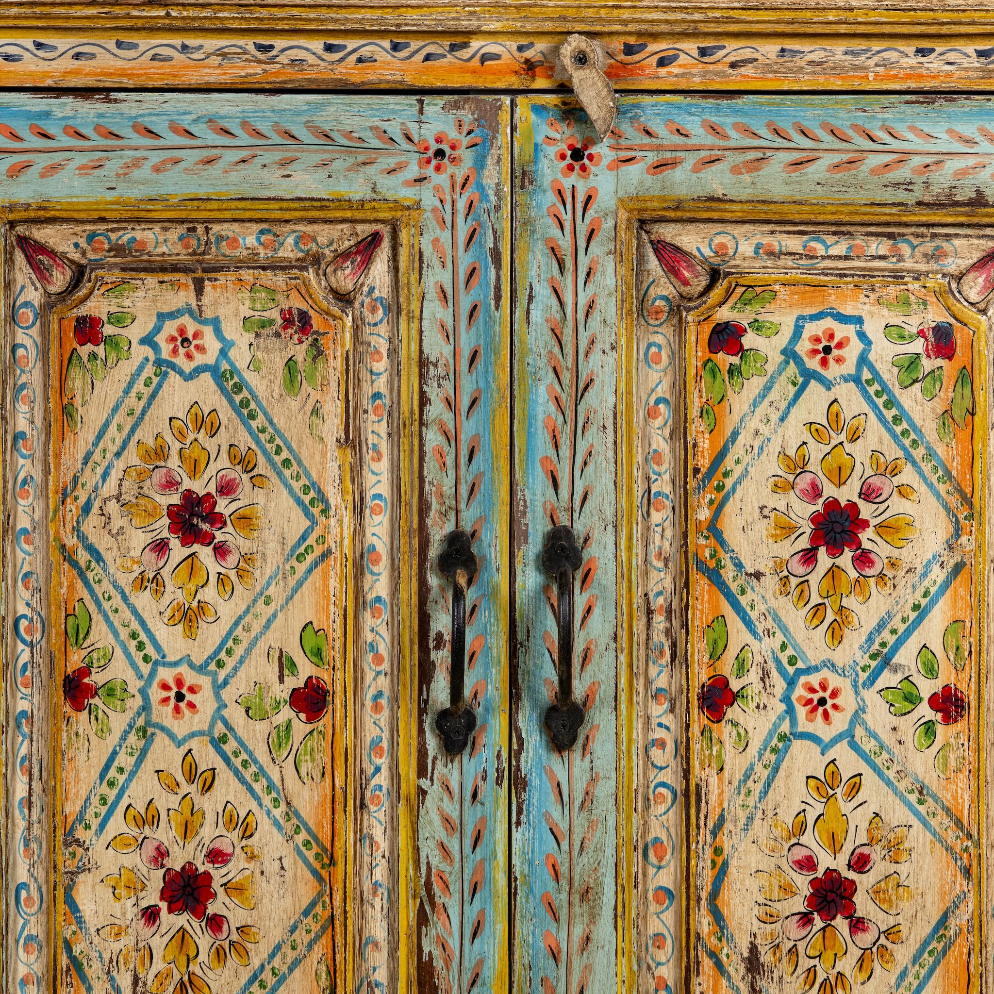 Close up image of a hand painted wooden dresser with floral and geometric motifs, reclaimed wood living room furniture in vintage boho style, 170 × 45 × 95 cm.