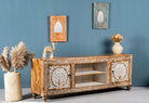 Side angle image of a whitewashed carved console table made of mango wood with floral motifs, four compartments; artisanal living room furniture, 180 × 40 × 65 cm.