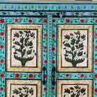 Close up image of a Hand-painted reclaimed wood cabinet with floral motifs and green frame – Drisina by Om Home & Garden, a unique piece of sustainable furniture with bohemian flair.