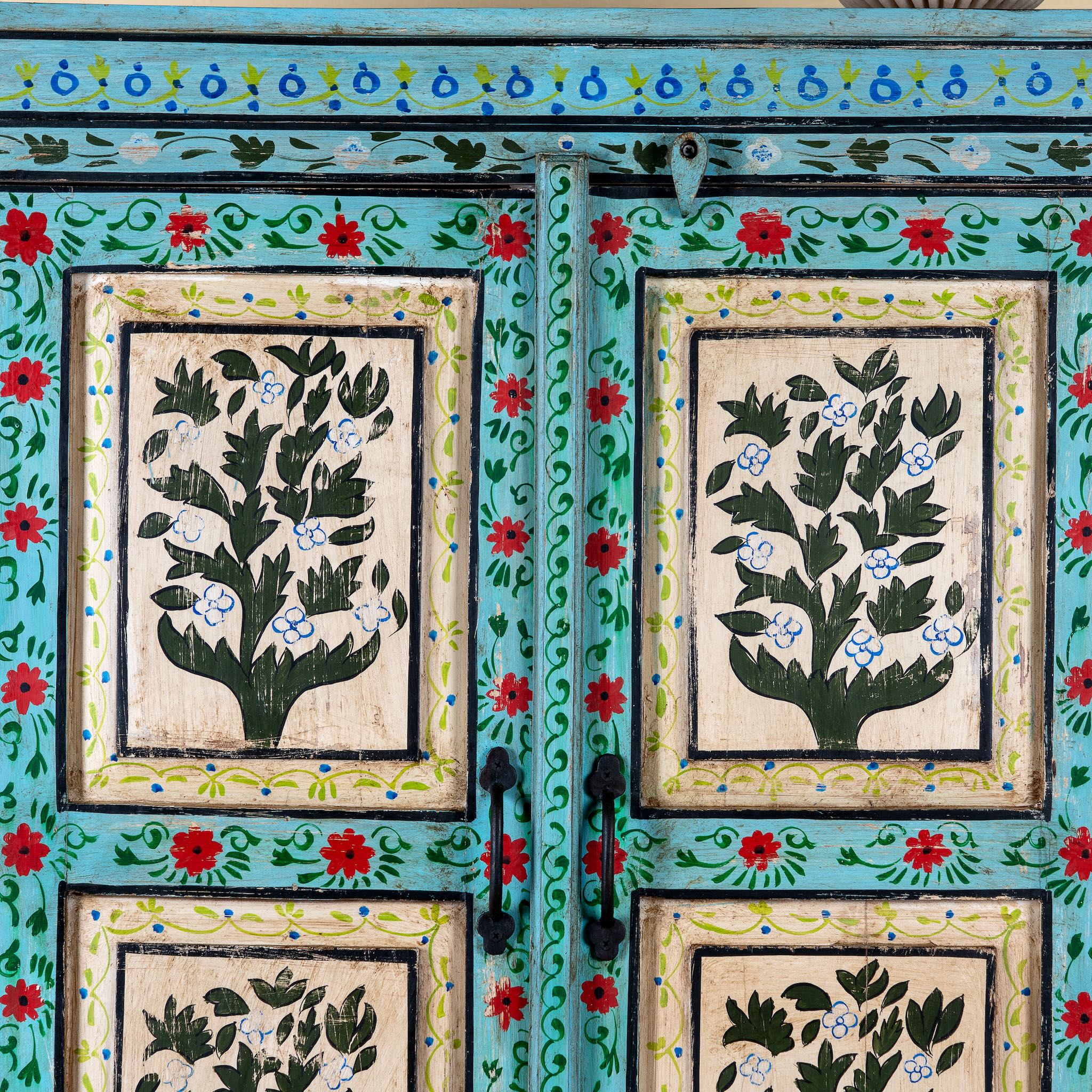 Close up image of a Hand-painted reclaimed wood cabinet with floral motifs and green frame – Drisina by Om Home & Garden, a unique piece of sustainable furniture with bohemian flair.