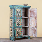 Side angle image with open doors of a hand-painted reclaimed wood cabinet with floral motifs and green frame – Drisina by Om Home & Garden, a unique piece of sustainable furniture with bohemian flair.
