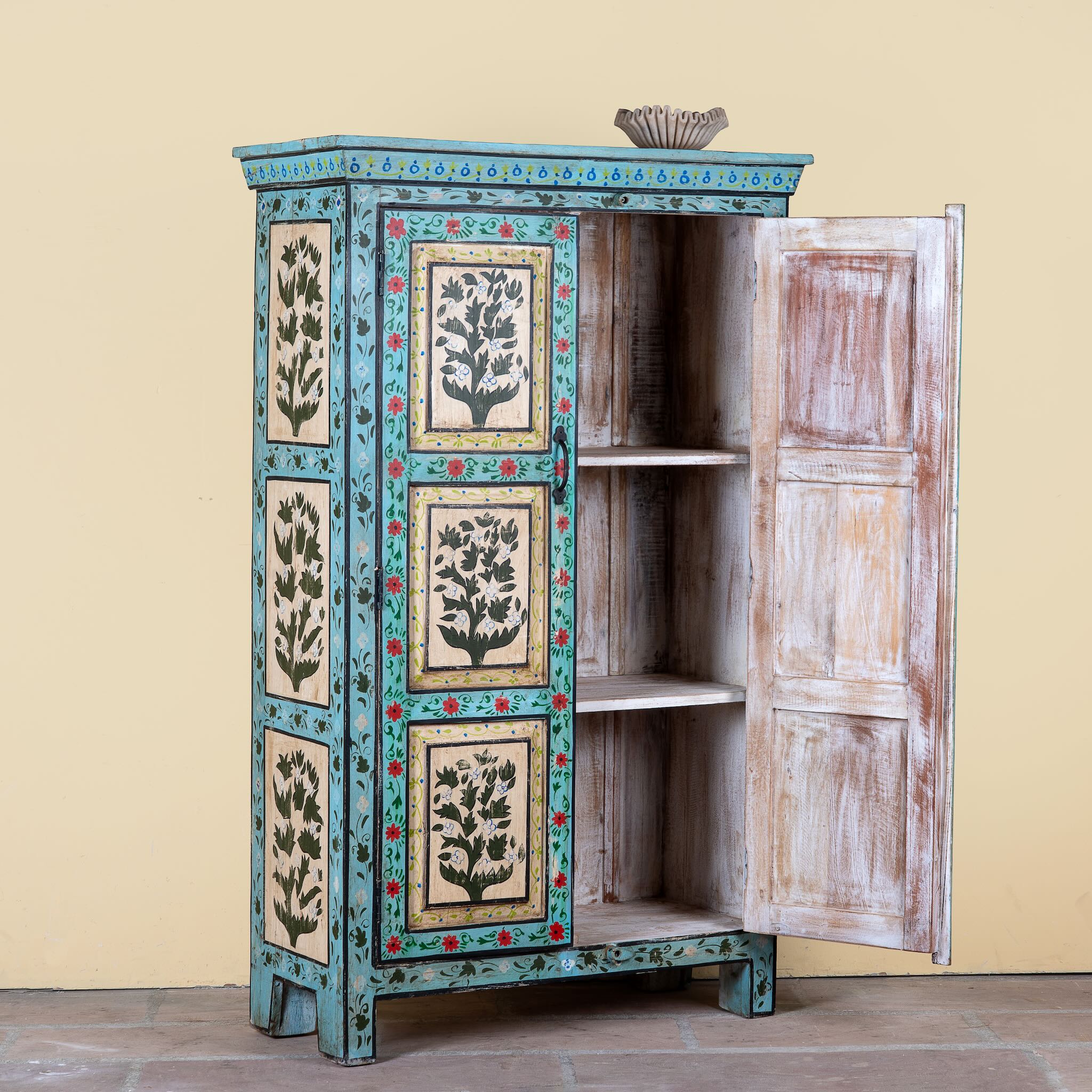 Side angle image with open doors of a hand-painted reclaimed wood cabinet with floral motifs and green frame – Drisina by Om Home & Garden, a unique piece of sustainable furniture with bohemian flair.
