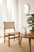 Lifestyle image of a Dwaraka Acacia wood chair with hand-woven cotton rope seat and backrest—an elegant piece of wooden seating and part of our artisan acacia wood chairs collection.