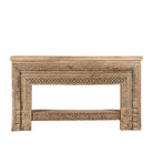 White background image of a ornate console table crafted from reclaimed teak wood and refurbished architectural elements, featuring intricate hand-carved detailing with floral and geometric motifs, showcasing a vintage artisanal aesthetic.
