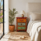 Lifestyle scene with a hand-painted vintage night stand with floral motifs – unique Indian furniture made from recycled wood for artistic and bohemian interiors.