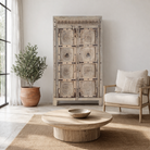 Lifestyle image of a reclaimed teak wood cabinet Elayna featuring an antique Indian door with carved motifs and iron accents. A unique piece of old door furniture in Mediterranean style, offering practical storage and historic charm.