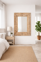 Lifestyle imagination of a carved mango wood mirror Indira with floral motifs and distressed finish. A handcrafted Indian furniture piece perfect for vintage home decor and artisanal interiors.