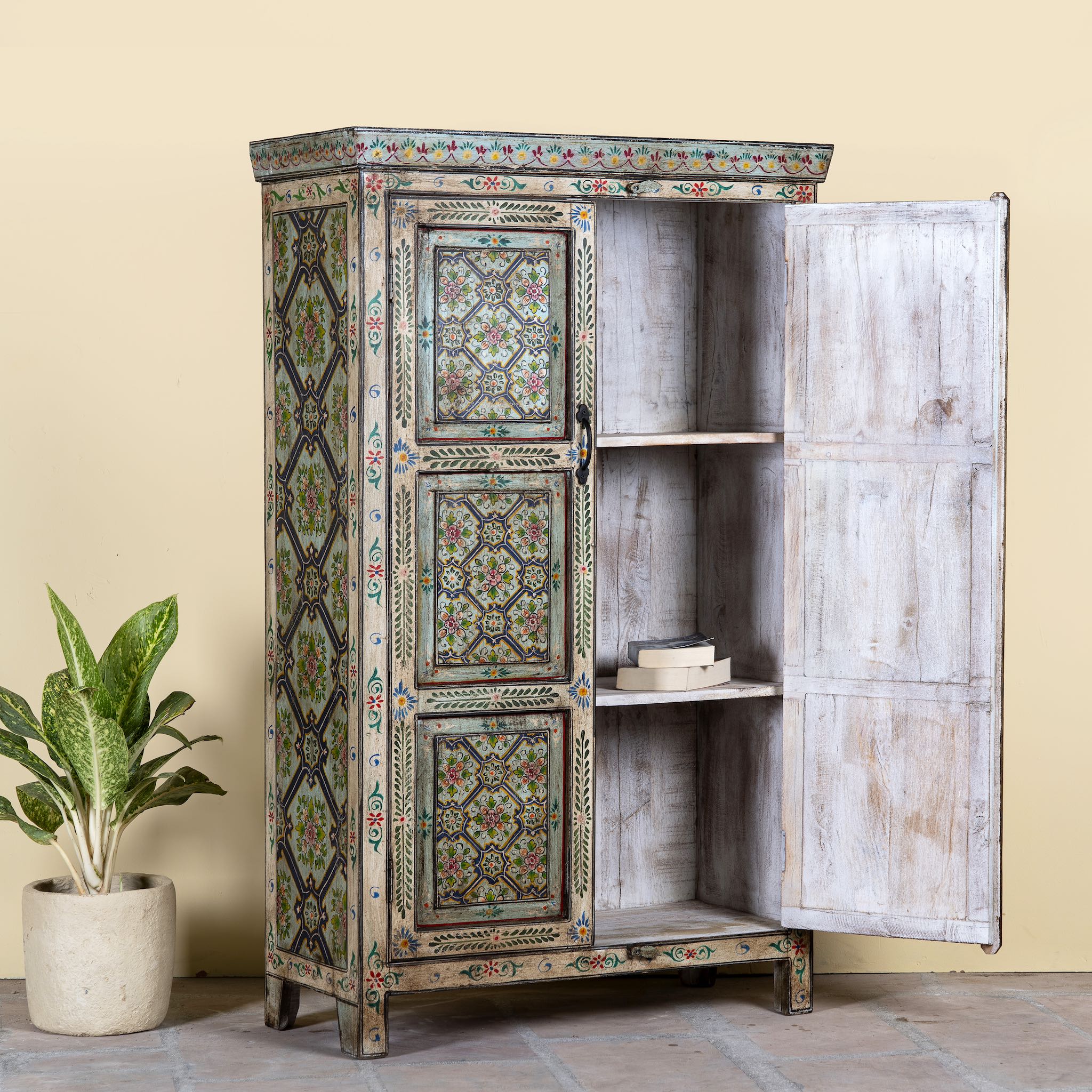 Open door image of a reclaimed wood cabinet with floral and geometric designs, perfect for a bohemian interior with Mediterranean style.