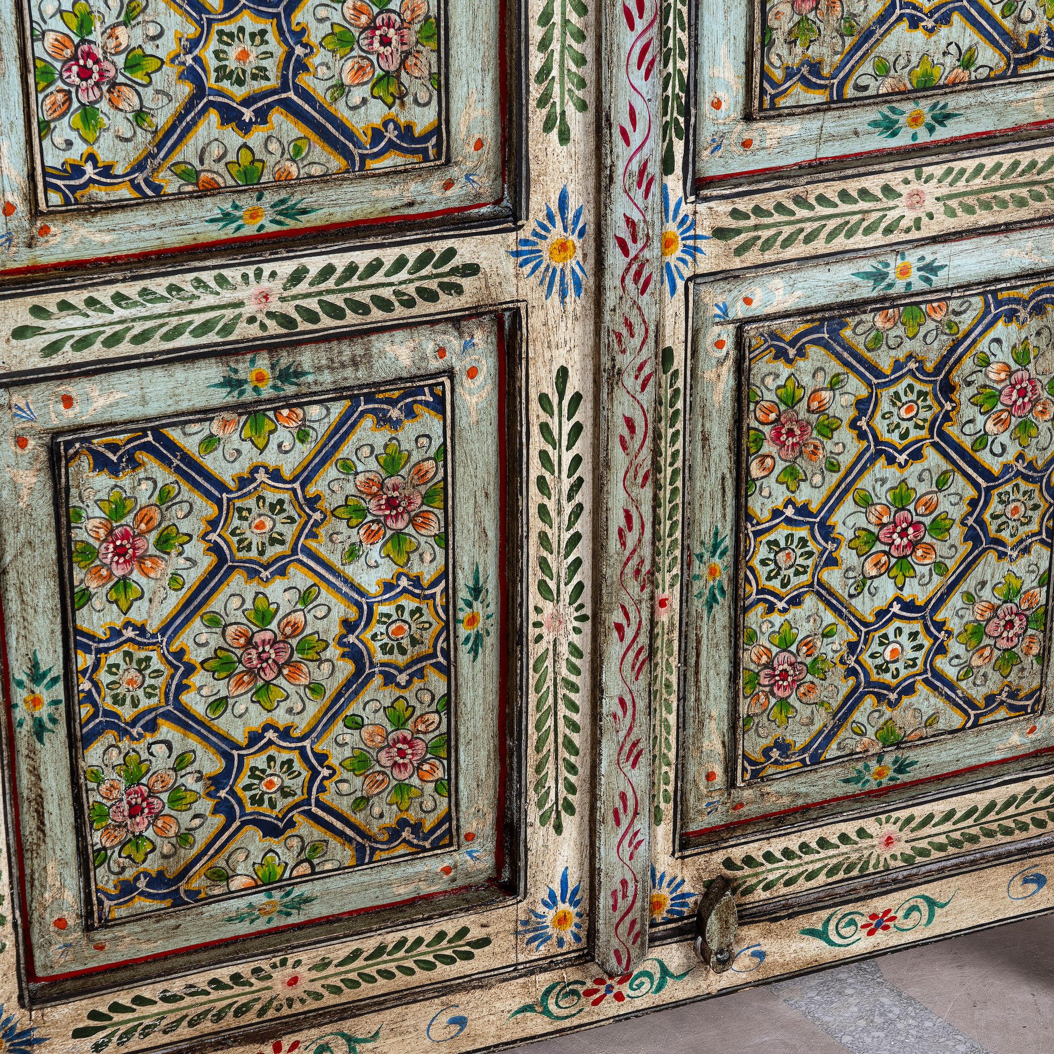 Close up image of a reclaimed wood cabinet with floral and geometric designs, perfect for a bohemian interior with Mediterranean style.
