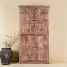 Front view of a hand crafted acacia wood cabinet with 4 doors, brass fitted door knobs and geometrical carvings.