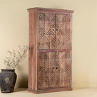 Side view of a hand crafted acacia wood cabinet with 4 doors, brass fitted door knobs and geometrical carvings.