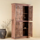 Open door view of a hand crafted acacia wood cabinet with 4 doors, brass fitted door knobs and geometrical carvings.