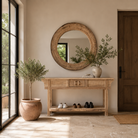 Lifestyle image of a round carved wooden mirror with reclaimed teak frame and rustic iron edging; Indian furniture online, 110 cm diameter, 8 cm deep.