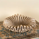 Hand-carved folded beige marble bowl with wave-shaped rim and radial design, ideal for vintage home decoration and Indian home decor.