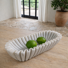 Lifestyle imagination of a elongated hand-carved white marble bowl with folded pleated edges – Indian decorative marble accessory.