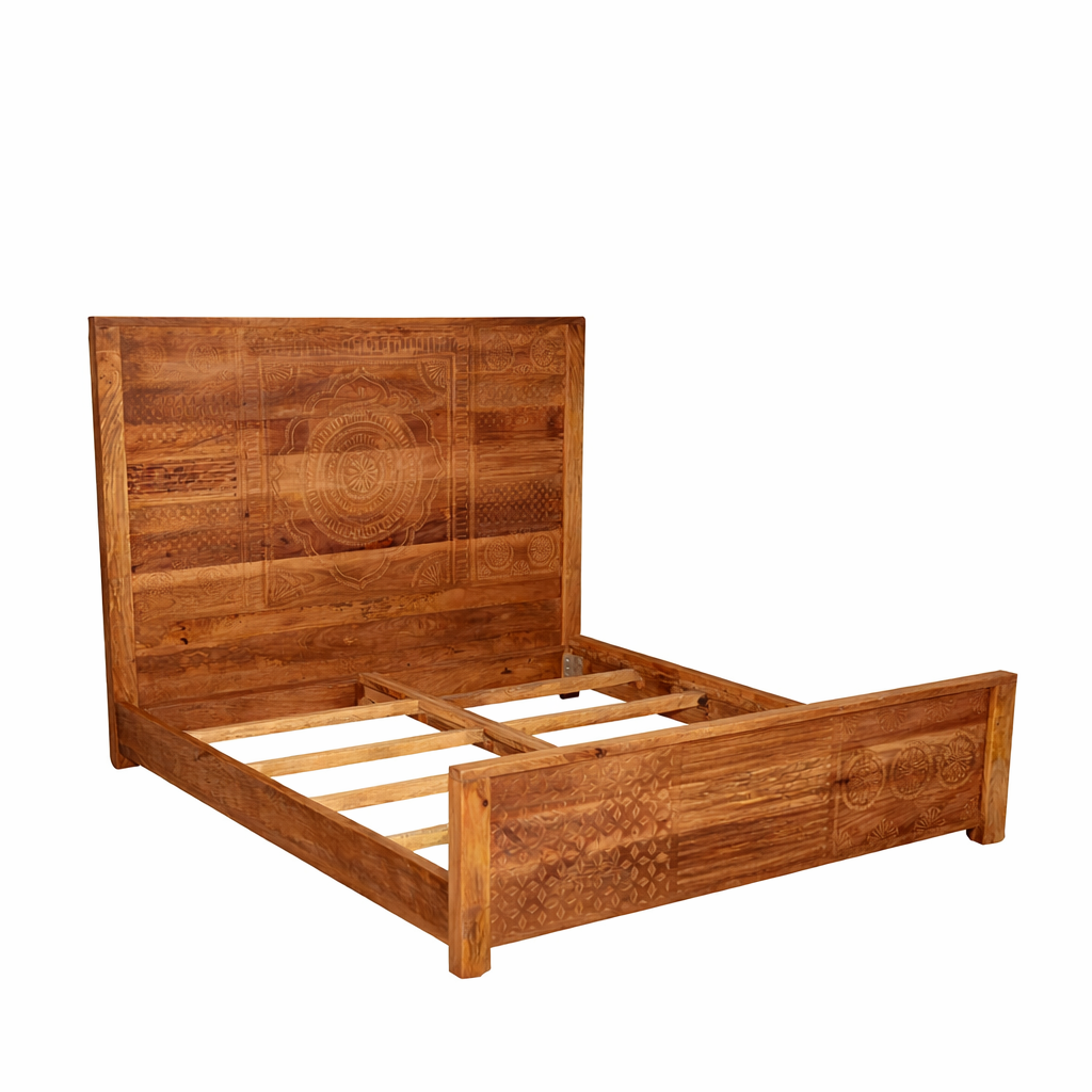 Side angle image of a hand carved mango wood bed frame in warm colours.