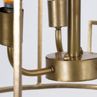 Close up image of a unique pendant light with round shiny brass-plated frame and magnifying glass inserts – vintage lighting with three-light design for dining rooms, kitchens, or elegant interiors.