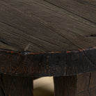 Close up picture of a rustic wood coffee table with round reclaimed teak top and black charred finish; sustainable furniture, 70 cm diameter, 40 cm height.