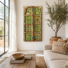Lifestyle image of a Giritra hand-painted teak door panel featuring floral motifs in soft pastels and a carved arched frame—an elegant and unique Indian wall decoration repurposed from antique architecture.