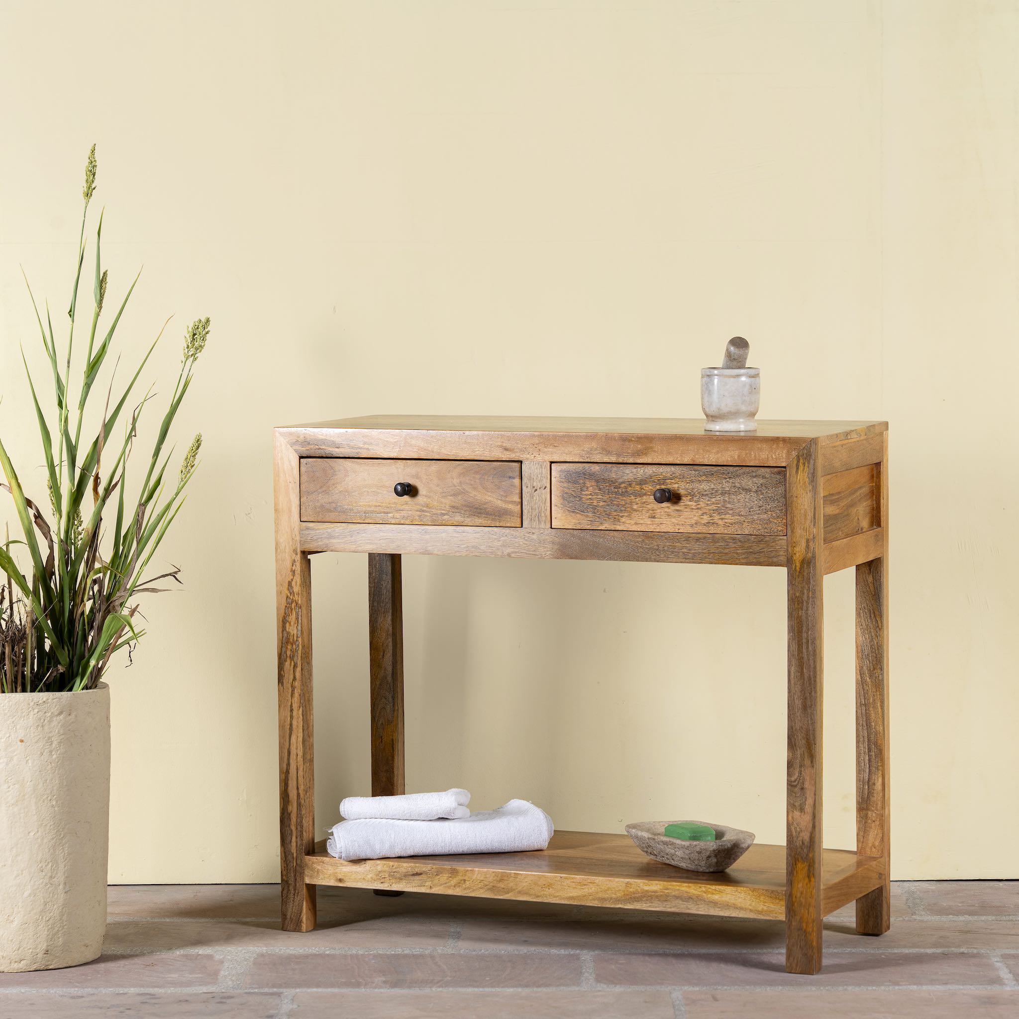 Side angle image of a Ibiza style reclaimed wood console table with two drawers and bottom shelf, warm natural finish, 100 × 40 × 90 cm.
