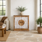 Lifestyle image of a carved wood furniture cabinet made from mango wood with floral whitewashed doors, 90 × 40 × 90 cm.