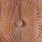Close up image of a acacia wood cabinet with hand-carved sunburst doors, grooved details, and one drawer, 90 × 40 × 90 cm.
