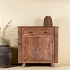 Acacia wood cabinet with hand-carved sunburst doors, grooved details, and one drawer, 90 × 40 × 90 cm.
