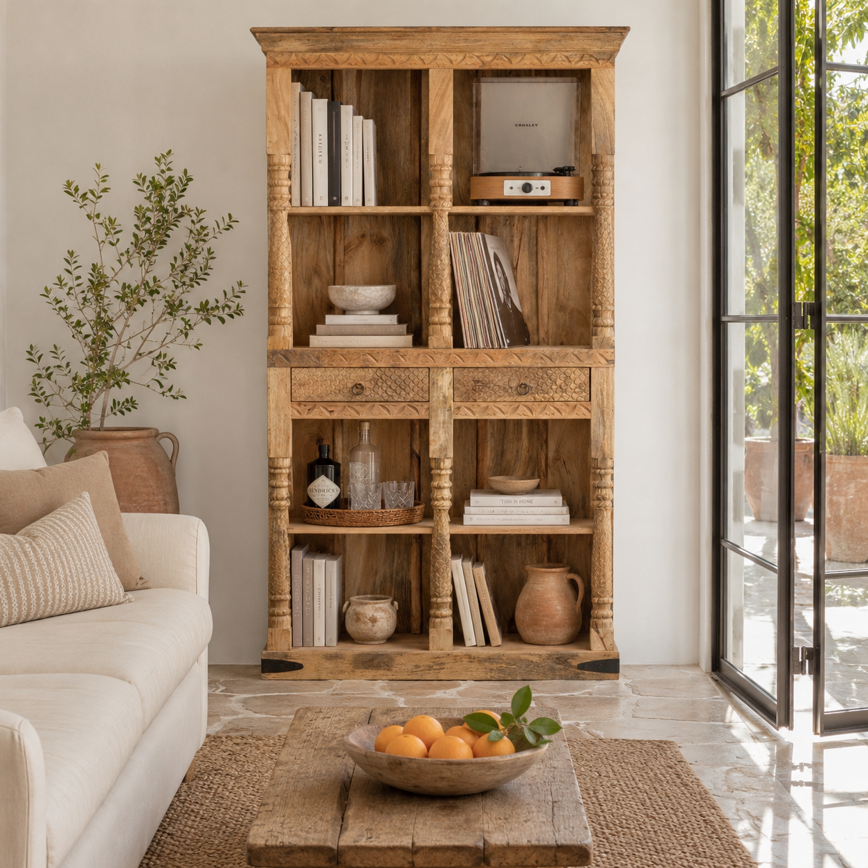 Lifestyle mage of a handcrafted mango wood bookshelf with carved detailing – mango wood shelving and carved wooden furniture in a warm brown finish for timeless interiors.
