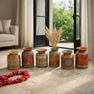 Life style image of a hand-painted papier-mâché vase Udanth in mixed colours with floral and folk motifs. A vintage home accessory and unique Indian decoration ideal for vintage home decor or use as a decorative statement vase.