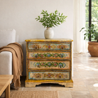 Lifestyle imagination of hand-painted reclaimed wood chest of drawers with floral designs and distressed antique finish; perfect for bohemian interiors and vintage hand painted furniture lovers.