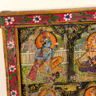 Close up image of a Krishna antique reclaimed wood mirror with hand-painted Radha and Krishna artwork, authentic Indian vintage mirror frame, 50x50x5cm.