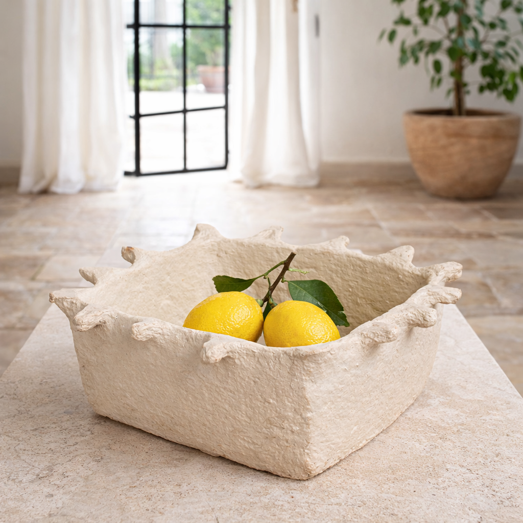 Lifestyle imagination of a handmade papier-mâché bowl Dityaa in matte white with jagged edges. A sustainable vintage home accessory perfect for unique Indian decoration and vintage home decor, used in bathrooms, kitchens, or for dried plants.