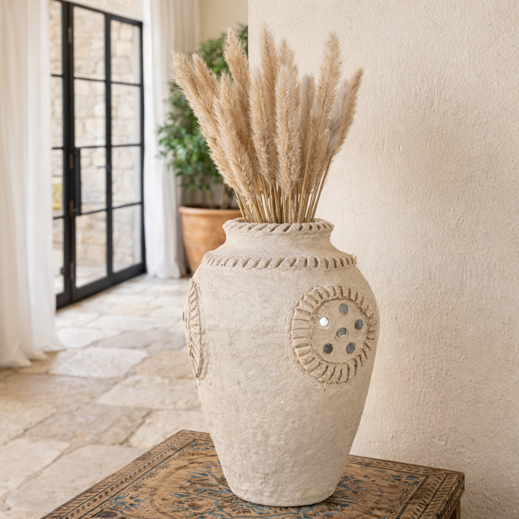 Lifestyle image of a handmade papier-mâché vase Kaju with decorative medallion and mirror inlay detail. A vintage home accessory and unique Indian decoration, ideal for vintage home decor with dried flowers or as a standalone statement.