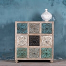 Mango wood chest of drawers Hansika with nine hand-carved floral drawer fronts in soft bohemian colours. A unique carved sideboard combining artisan design with versatile storage.