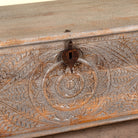 Close up image of a Harivansh hand carved mango wood chest with floral design and distressed vintage finish 180cm