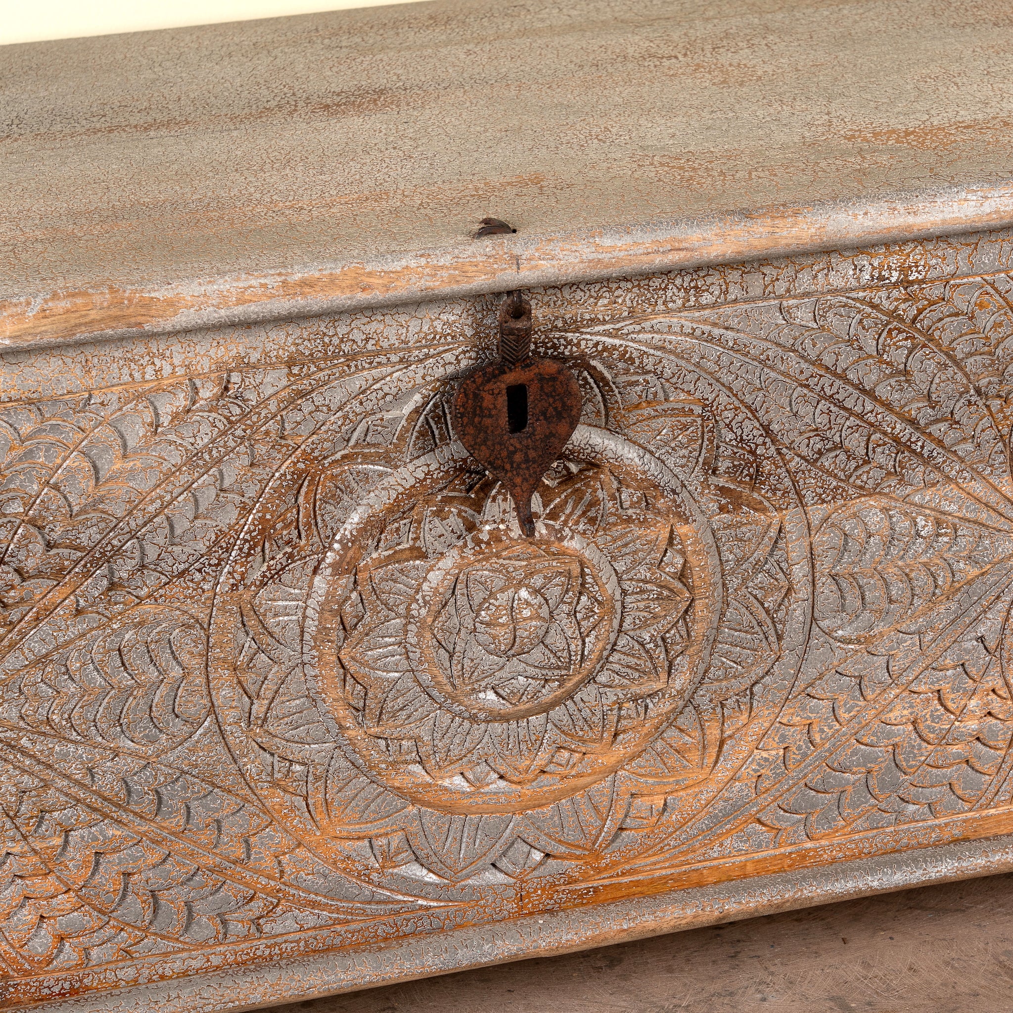Close up image of a Harivansh hand carved mango wood chest with floral design and distressed vintage finish 180cm