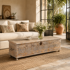 Lifestyle image of a Harivansh hand carved mango wood chest with floral design and distressed vintage finish 180cm