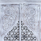 Closed up image of a white-washed hand-carved wooden wardrobe made of solid mango wood, vintage furniture with Mediterranean Ibiza style, 180 × 90 × 40 cm.