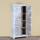 Side angle image with open door of a white-washed hand-carved wooden wardrobe made of solid mango wood, vintage furniture with Mediterranean Ibiza style, 180 × 90 × 40 cm.