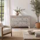 Lifestyle imagintion of a of a handcrafted chest of drawers Hemali made from reclaimed wood, featuring four carved drawers with circular motifs and a whitewashed finish. A rustic, sustainable furniture piece with soft texture and elegant detailing.
