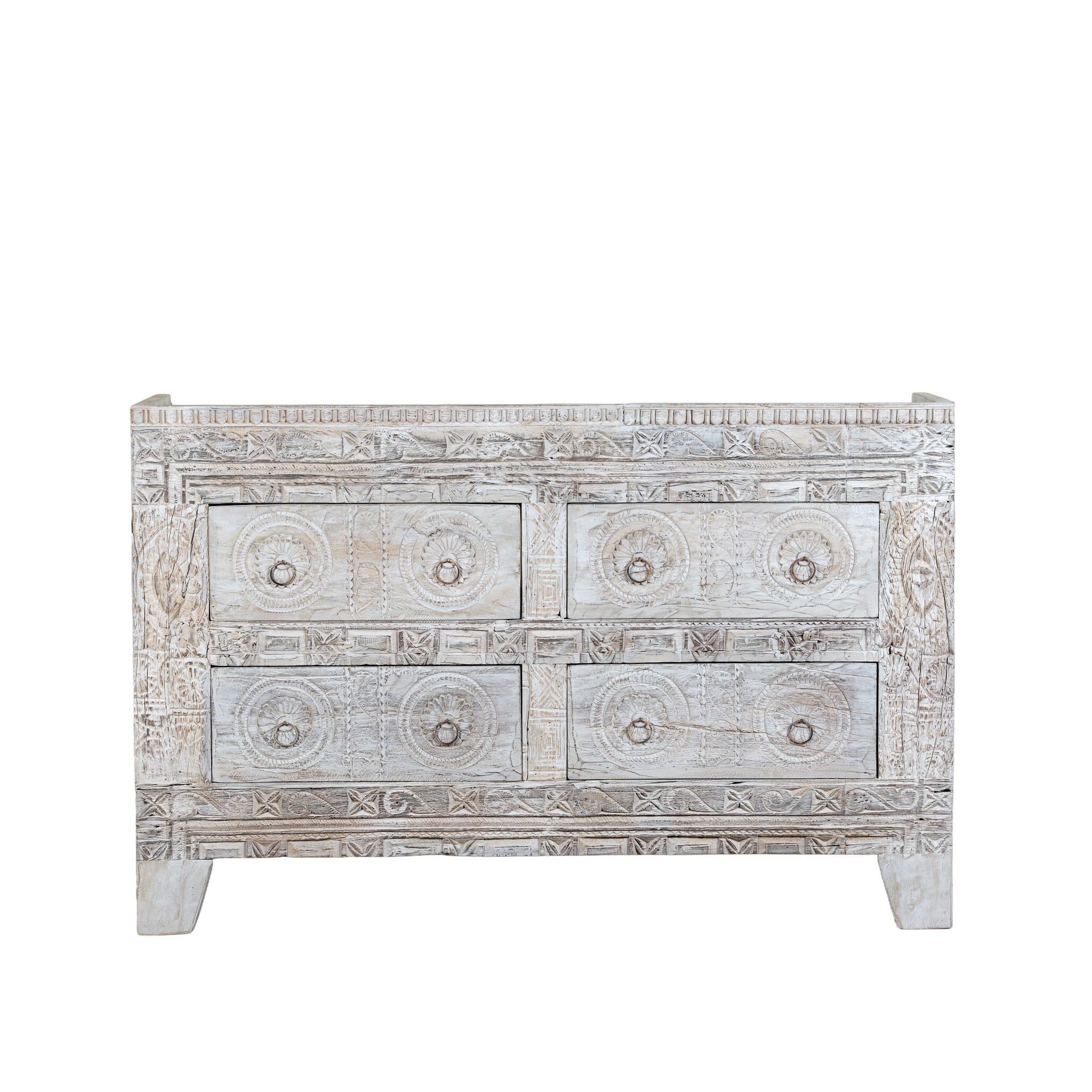 White background image of a handcrafted chest of drawers Hemali made from reclaimed wood, featuring four carved drawers with circular motifs and a whitewashed finish. A rustic, sustainable furniture piece with soft texture and elegant detailing.